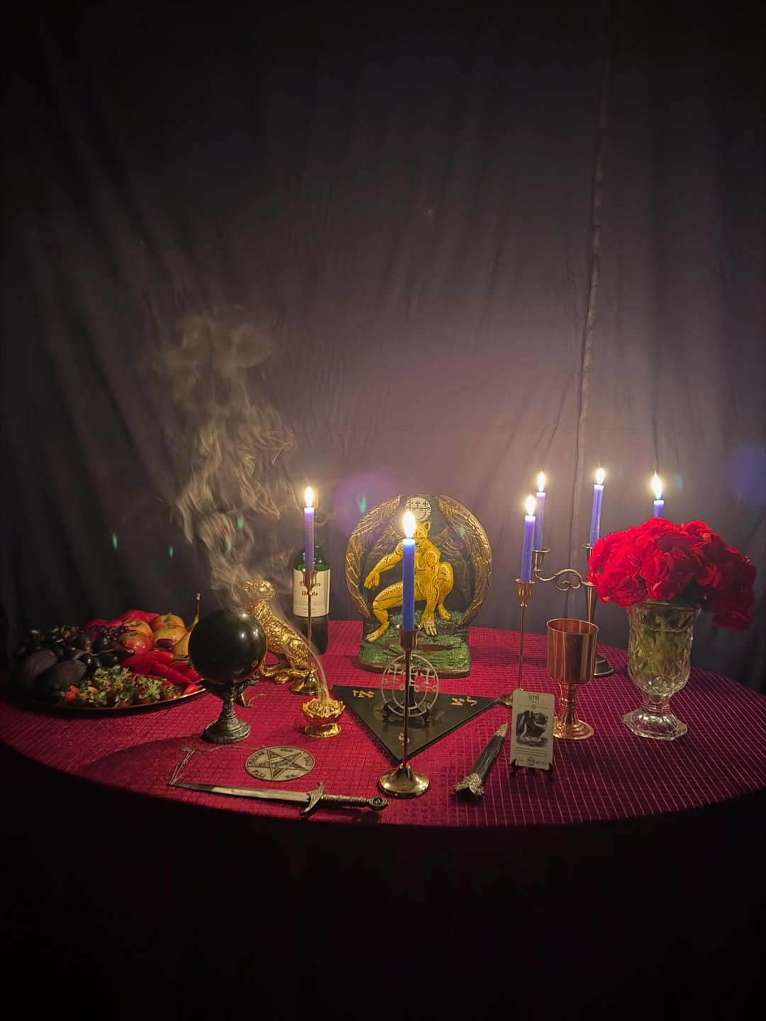 Altar com rosas vermelhas, velas e esfera de obsidiana