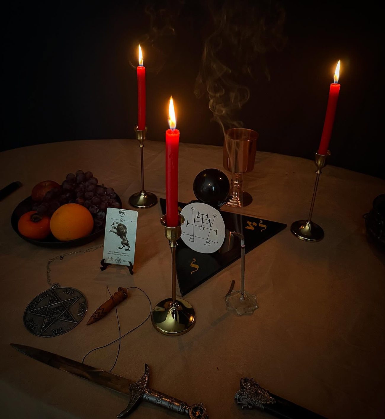 Altar com velas vermelhas, triângulo da arte e selo goético